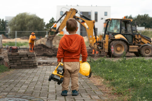 Child with excavator looks at bulldozer, representing donors' wish to support career education programs.