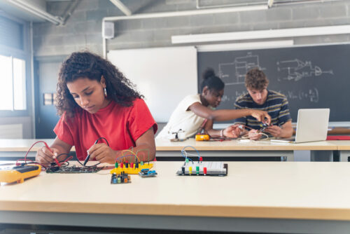 Gen Z high schoolers studying robotics and STEM education, representing Gallup and Walton Family Foundation survey of Gen Z careers in technology