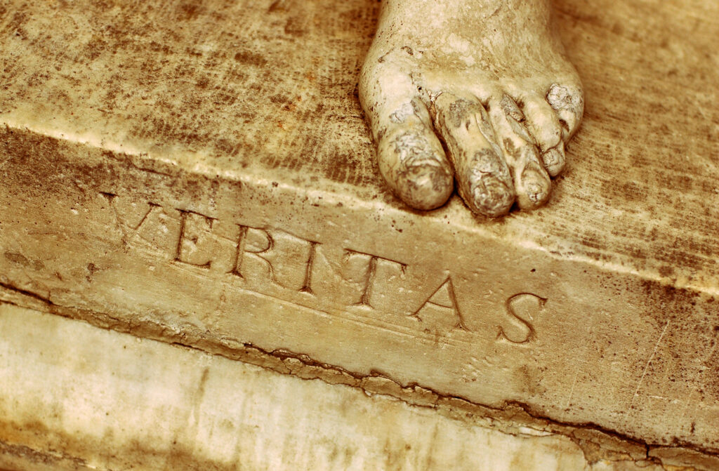 Foot with veritas engraved, indicating universities' proper mission as bastions of truth.