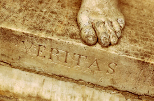 Foot with veritas engraved, indicating universities' proper mission as bastions of truth.