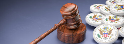 A judges gavel on its base surrounded by logos of the Supreme Court of the United States SCOTUS. Selective focus