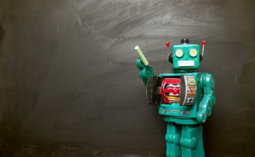 Big cyan blue robot toy teaches his class , blackboard and copy space